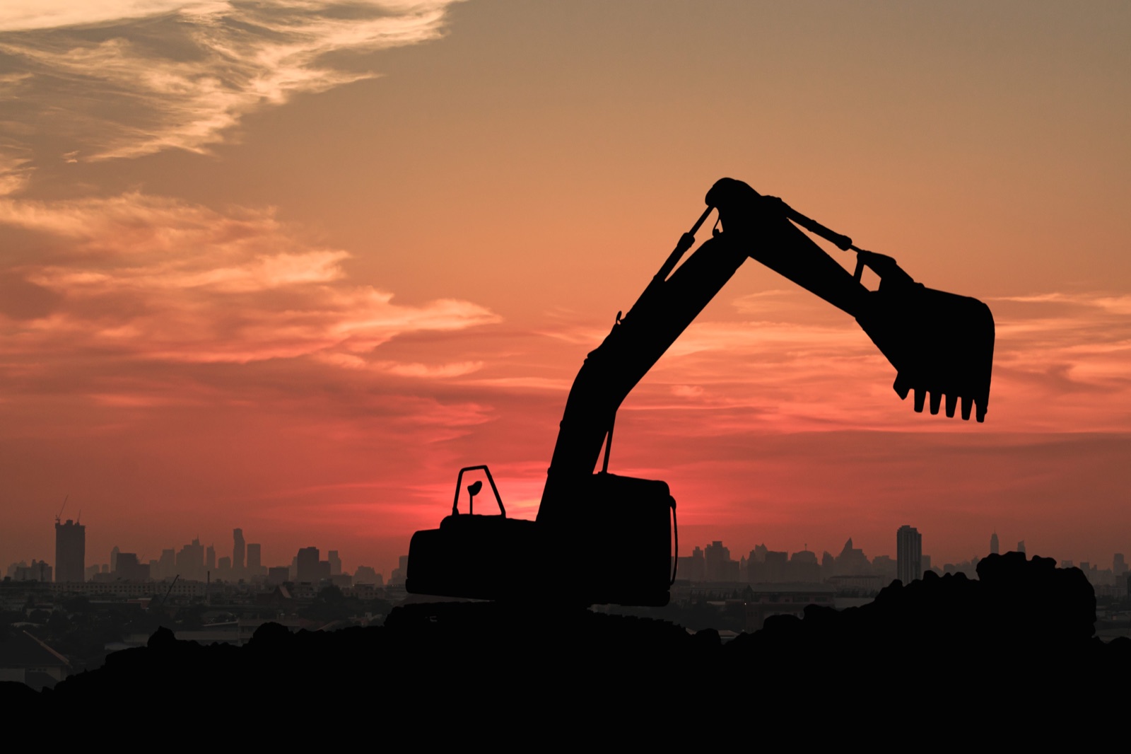 Excavators working on a construction site at sunset