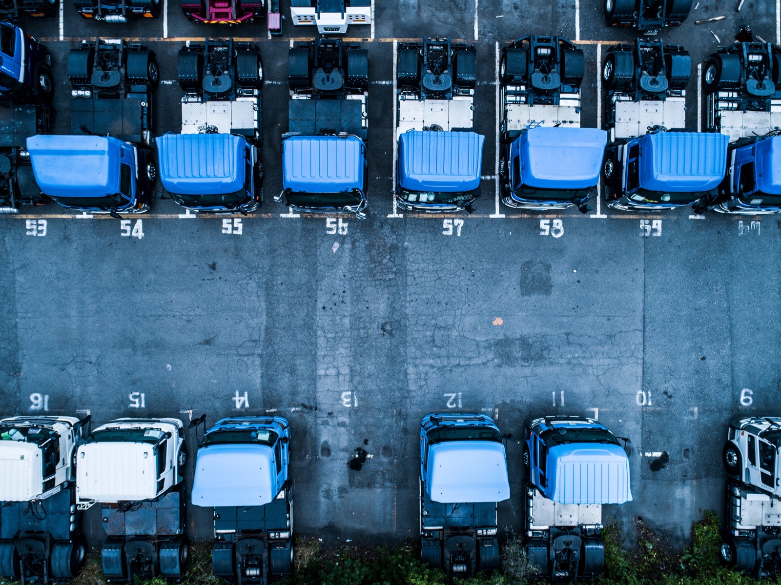 Aerial view of a fleet of trucks parked in rows at a depot