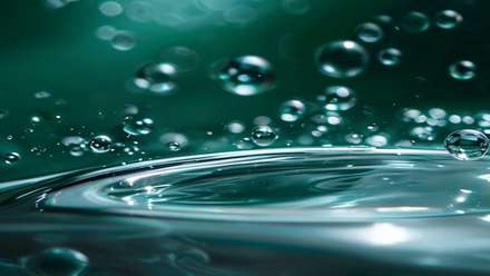 Reflective metallic surface covered in water droplets